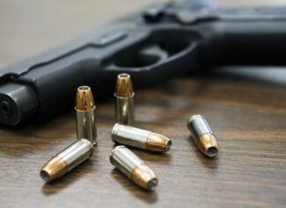 Handgun with bullets on a wooden table